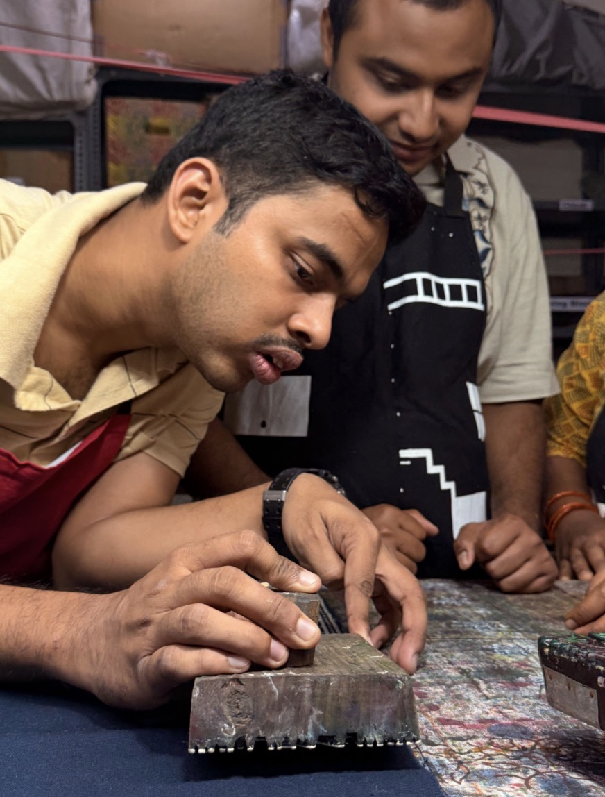 Trainee carefully aligning a wooden block for printing